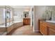 Bathroom featuring a soaking tub, double vanity, and neutral tile at 9636 W 71St Pl, Arvada, CO 80004