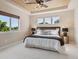 Relaxing bedroom with a large window, tray ceiling, and neutral color palette at 9636 W 71St Pl, Arvada, CO 80004