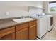 Convenient laundry room featuring a sink, counter space, cabinets, washer, and dryer at 9636 W 71St Pl, Arvada, CO 80004