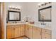 Bright bathroom featuring double sinks, wooden cabinetry, and ample counter space at 2505 Big Bear Cir, Sedalia, CO 80135