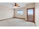 Bright bedroom with a ceiling fan, neutral carpet, and private balcony access at 2505 Big Bear Cir, Sedalia, CO 80135
