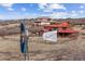 Exterior view of a home with wooden fences, an antique windwill, and vast land at 2505 Big Bear Cir, Sedalia, CO 80135