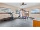 Spacious home gym featuring a treadmill, weight rack, rubber floor, and natural light from large windows at 2505 Big Bear Cir, Sedalia, CO 80135