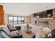 Bright living room with stone fireplace, large windows, and access to the outdoor pool at 2505 Big Bear Cir, Sedalia, CO 80135