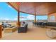 Covered patio with outdoor kitchen, fire pit, dining area, and views of the pool and landscape at 2505 Big Bear Cir, Sedalia, CO 80135