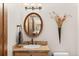 Stylish powder room with oval mirror, stone countertop, and decorative accents at 2505 Big Bear Cir, Sedalia, CO 80135