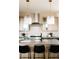 Modern kitchen island and countertops with stainless steel range, vent hood, and tile backsplash at 2753 Curtis St, Denver, CO 80205
