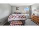 Cozy bedroom with a window and wood dresser at 3335 S Monaco Pkwy # D, Denver, CO 80222