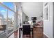 Open-concept view showcasing the dining area connecting to the living room with hardwood floors and large windows at 3335 S Monaco Pkwy # D, Denver, CO 80222