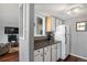 Kitchen with white cabinets, dark countertops, and a view of the living area at 3335 S Monaco Pkwy # D, Denver, CO 80222