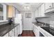 Efficient galley-style kitchen with white cabinets, dark countertops, and appliances at 3335 S Monaco Pkwy # D, Denver, CO 80222