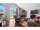 Inviting living room featuring vaulted ceilings, a brick fireplace, hardwood floors, and access to the deck at 3335 S Monaco Pkwy # D, Denver, CO 80222