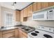 Functional kitchen with wood cabinets, granite countertops, and modern appliances at 1024 E 14Th Ave # 10, Denver, CO 80218