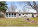 Spacious backyard featuring a patio, fire pit, and mature trees, perfect for outdoor gatherings at 10050 W 8Th Pl, Lakewood, CO 80215