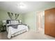 Well-lit bedroom with plush carpeting, queen-size bed and serene, pale green walls at 10050 W 8Th Pl, Lakewood, CO 80215