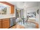 Cozy dining area with natural light, featuring modern light fixture, stainless steel dishwasher and wood flooring at 10050 W 8Th Pl, Lakewood, CO 80215