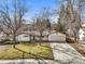 Inviting one-level home featuring a two-car garage, cozy front porch, and a well-kept green yard at 10050 W 8Th Pl, Lakewood, CO 80215