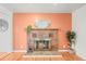 Brick fireplace with hearth in room with hardwood floors and bright coral wall at 10050 W 8Th Pl, Lakewood, CO 80215