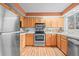 Bright kitchen featuring wood cabinets, stainless steel appliances, and white countertops, offering a clean and functional space at 10050 W 8Th Pl, Lakewood, CO 80215