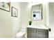 Half bathroom featuring modern vanity with gold hardware, decorative mirror, and stylish decor at 4401 S Clarkson St, Englewood, CO 80113