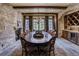 Dining room with a large wooden table, stone wall, fireplace, and arched alcove with built-in cabinets at 327 Peerless Dr, Breckenridge, CO 80424