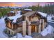 Beautiful stone and wood home featuring a balcony and mountain views in a snowy, wooded landscape at 327 Peerless Dr, Breckenridge, CO 80424