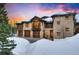 Eye-catching stone and wood home with a three car garage in a snowy, tree-lined neighborhood at 327 Peerless Dr, Breckenridge, CO 80424
