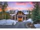 Striking stone and wood facade home with a private driveway, set against a backdrop of snowy mountains at 327 Peerless Dr, Breckenridge, CO 80424