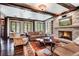 Open living area with stone fireplace, wood beams, built-in shelving, and large windows for natural light at 327 Peerless Dr, Breckenridge, CO 80424