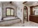 Stone tiled main bathroom with a soaking tub beneath a shuttered window, vanity, and separate toilet room at 327 Peerless Dr, Breckenridge, CO 80424