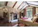 Main bedroom featuring a stone fireplace, wood-beamed ceiling, hardwood floors and balcony access at 327 Peerless Dr, Breckenridge, CO 80424