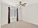 An empty bedroom with carpet, ceiling fan and a window covered with blinds and curtains at 8380 Blackgum St, Parker, CO 80134