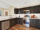 Bright kitchen showcasing granite countertops, stainless steel appliances, dark cabinetry, and hardwood flooring at 8380 Blackgum St, Parker, CO 80134