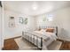 This is a bedroom with natural light and a black metal frame bed with neutral colored bedding at 7987 Durango St, Denver, CO 80221