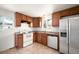 Efficient kitchen featuring wood cabinetry, white appliances, and tile flooring for easy maintenance at 7987 Durango St, Denver, CO 80221