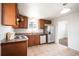 Efficient kitchen featuring wood cabinetry, white appliances, and tile flooring for easy maintenance at 7987 Durango St, Denver, CO 80221