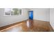 Well-lit living room with hardwood floors and a bright blue front door at 7987 Durango St, Denver, CO 80221