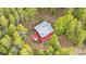 Bird's-eye view of a cozy red home nestled among vibrant green trees, offering a peaceful retreat at 154 Apache Rd, Evergreen, CO 80439