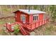 Cozy red cabin featuring a charming deck nestled in a serene wooded setting at 154 Apache Rd, Evergreen, CO 80439