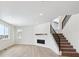 Spacious living room featuring a modern fireplace, wood-look floors, and staircase with black metal railing at 5525 Riverbend Ave, Firestone, CO 80504