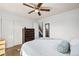 Bright bedroom with ceiling fan features two dressers, closet, and cozy carpet at 3095 W Harvard Ave, Denver, CO 80219