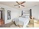 Bright bedroom with ample natural light features a ceiling fan, carpeted floor, and a mirror at 3095 W Harvard Ave, Denver, CO 80219