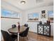 Bright dining area with wood floors, a round table, and natural light from the windows at 3095 W Harvard Ave, Denver, CO 80219