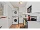 Modern kitchen featuring stacked washer and dryer, white cabinets and white appliances at 3095 W Harvard Ave, Denver, CO 80219