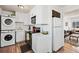 Well-lit kitchen featuring modern appliances, white cabinets and an adjacent washer and dryer at 3095 W Harvard Ave, Denver, CO 80219