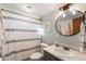 Bathroom featuring a neutral color scheme, shower with curtain, toilet, vanity, and round mirror at 7216 S Lincoln Way, Centennial, CO 80122