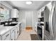 Bright kitchen with white cabinets, stainless steel appliances, and black backsplash at 7216 S Lincoln Way, Centennial, CO 80122