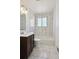 Modern bathroom featuring marble floors and tiled shower, plus a dark wood vanity at 3150 W Mexico Ave, Denver, CO 80219