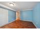 Bedroom features wood-look floors, blue walls, and an open door leading to the staircase at 3150 W Mexico Ave, Denver, CO 80219