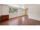 Bright bedroom with hardwood floors and decorative wood accent wall, complemented by a window and dresser at 3150 W Mexico Ave, Denver, CO 80219